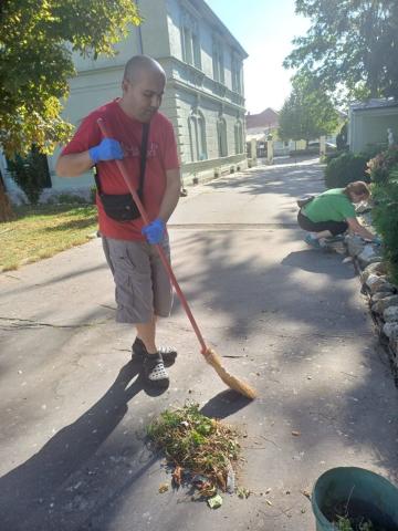 Prijímatelia sociálnej služby pri upratovaní dvora v rámci jesennej brigády.